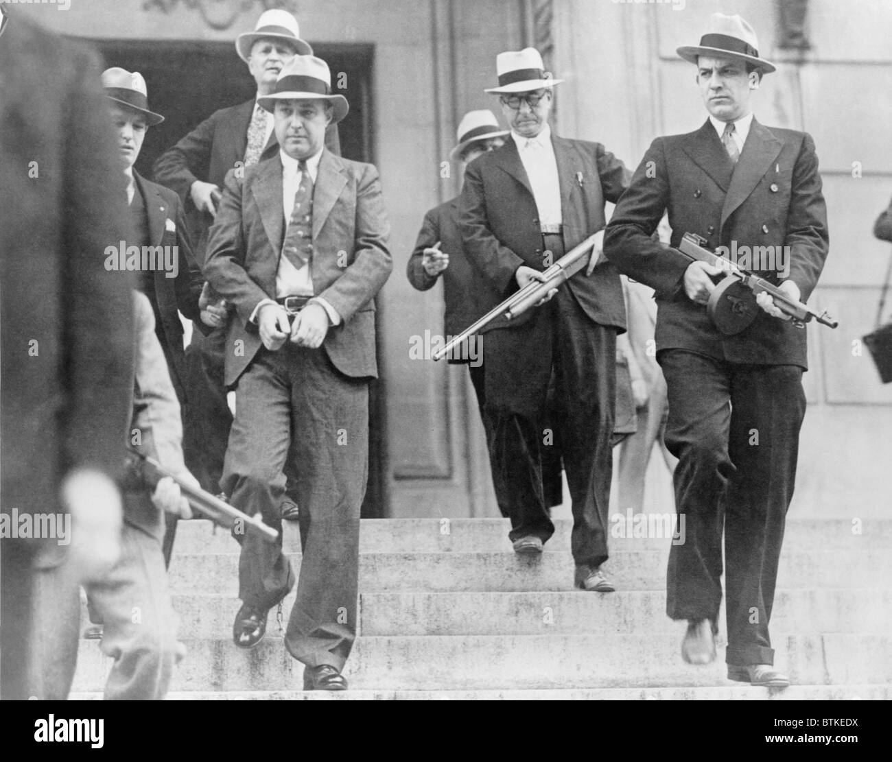 George "Machine Gun" Kelly (1897-1954), mit Handschellen gefesselt, gefesselt unter strenger Bewachung unterwegs Oklahoma City versucht werden, für die Entführung des Charles F. Urschel. Er wurde verurteilt und verbrachte den Rest seines Lebens im Gefängnis sterben in Alcatraz. Stockfoto