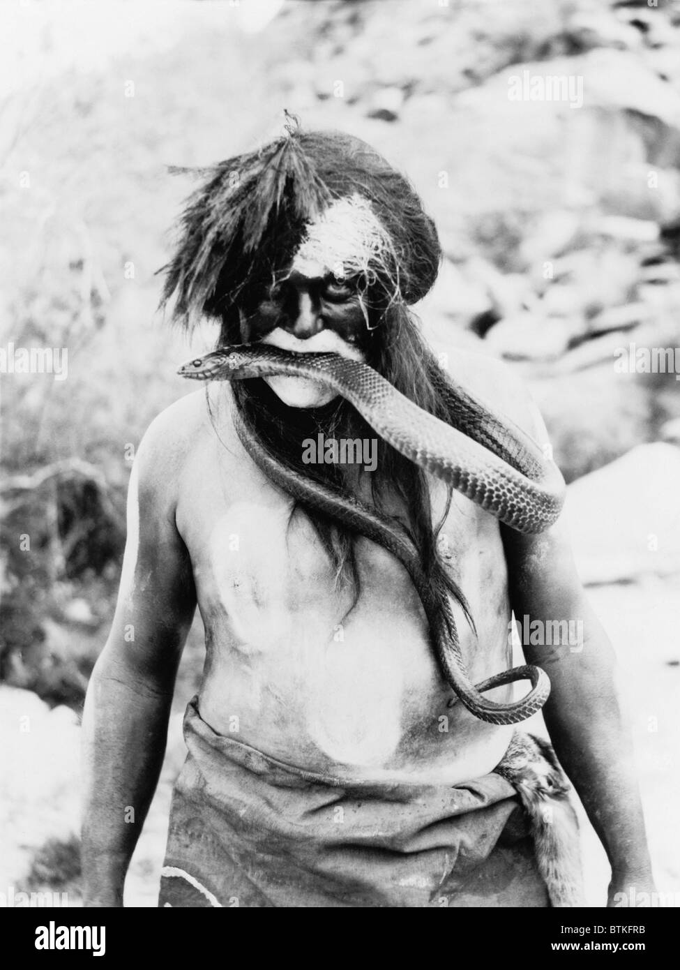 Hopi-Indianer mit bemaltem Gesicht, Körper und Schlange im Mund. Foto von Ralph Murphy, 1924. Stockfoto