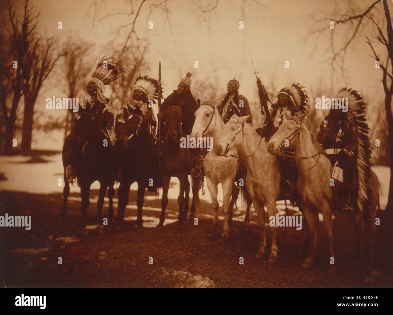 Indianischer Stammesführer in Kostüm und auf dem Pferderücken. Von links nach rechts: kleine Plume (Piegan), Buckskin Charley (Ute), Geronimo (Chiricahua Apache), Quanah Parker (Comanche), Hollow Horn tragen (Brule Sioux) und American Horse (Oglala Sioux). Foto von Edward Curtis. Stockfoto