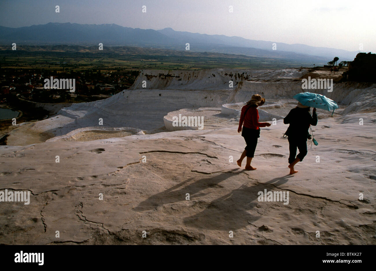 Zwei japanische Touristen zu Fuß über die weiße Travertin von Pamukkale, Provinz Denizli, Türkei Stockfoto