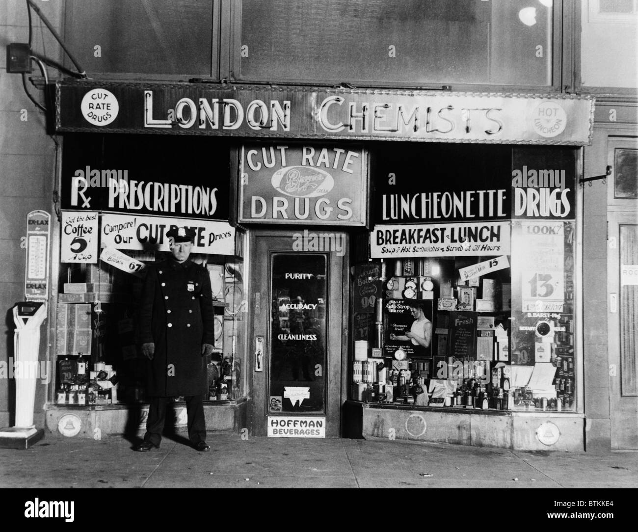 Ein New Yorker Polizisten bewachen den Tatort, wo Gangster Vincent Coll von Dutch Schultz Assassinen an der Eighth Avenue und 23rd Street ermordet wurde. 8. Februar 1932. Stockfoto