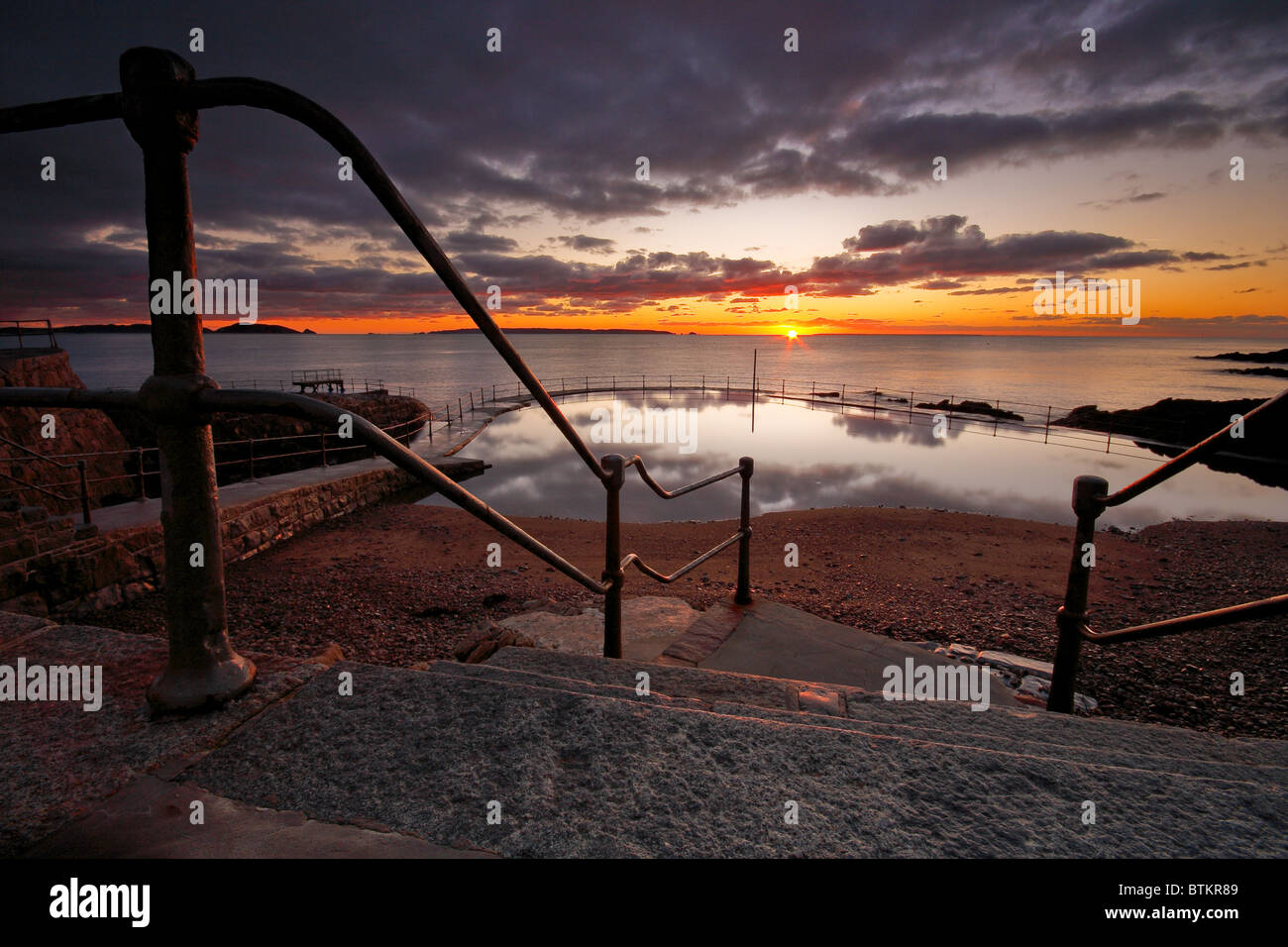 Das Badebecken bei Sonnenaufgang mit Blick auf den Rest der Kanalinseln Stockfoto