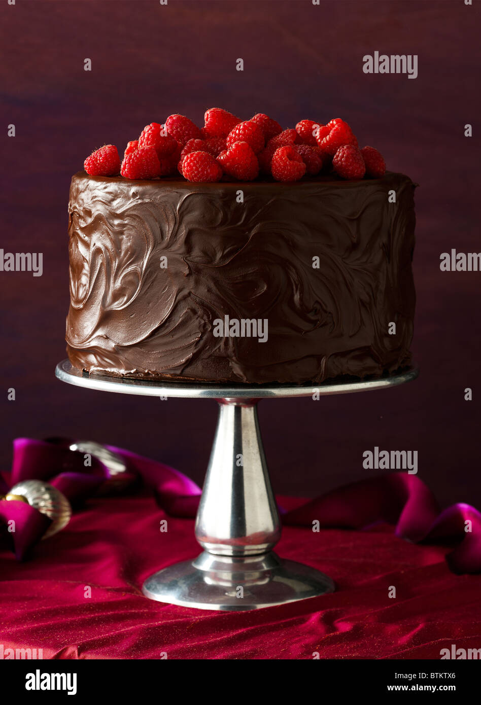 Schokoladen-Kuchen mit Schokolade Zuckerguss und Himbeeren auf einem Urlaub Tisch. Stockfoto