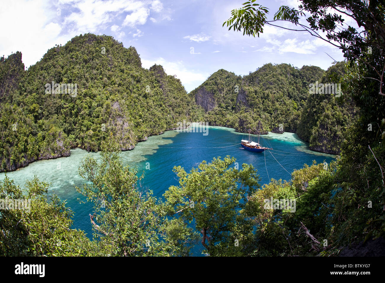 Umgeben von Kalksteininseln, liegt eine kleine indonesische Tauchsafari auf einem atemberaubenden Ankerplatz in der Nähe von Misool Insel in Indonesien. Stockfoto