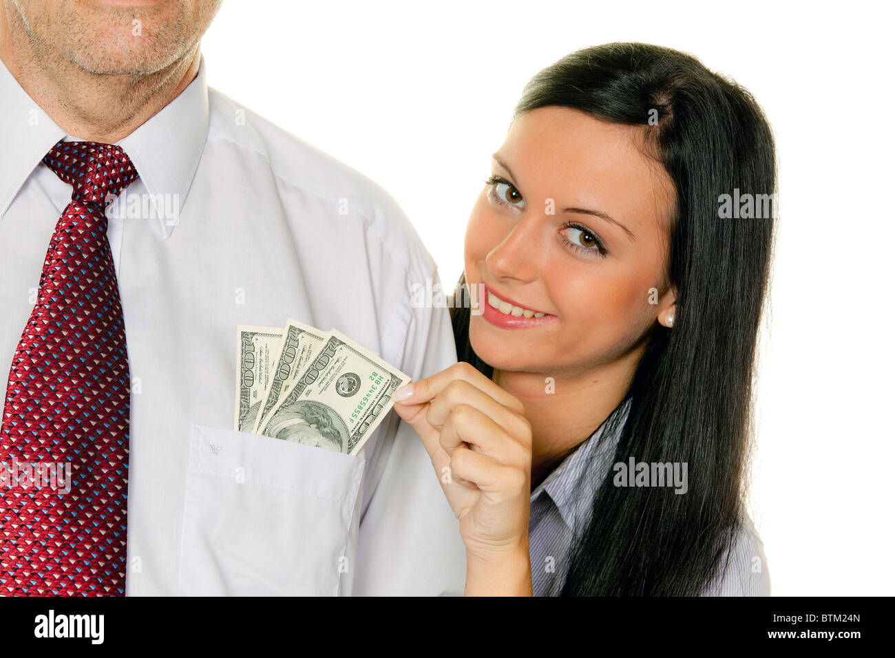 Eine junge Frau zieht das Geld aus der Tasche eines Mannes. Dollar Stockfoto