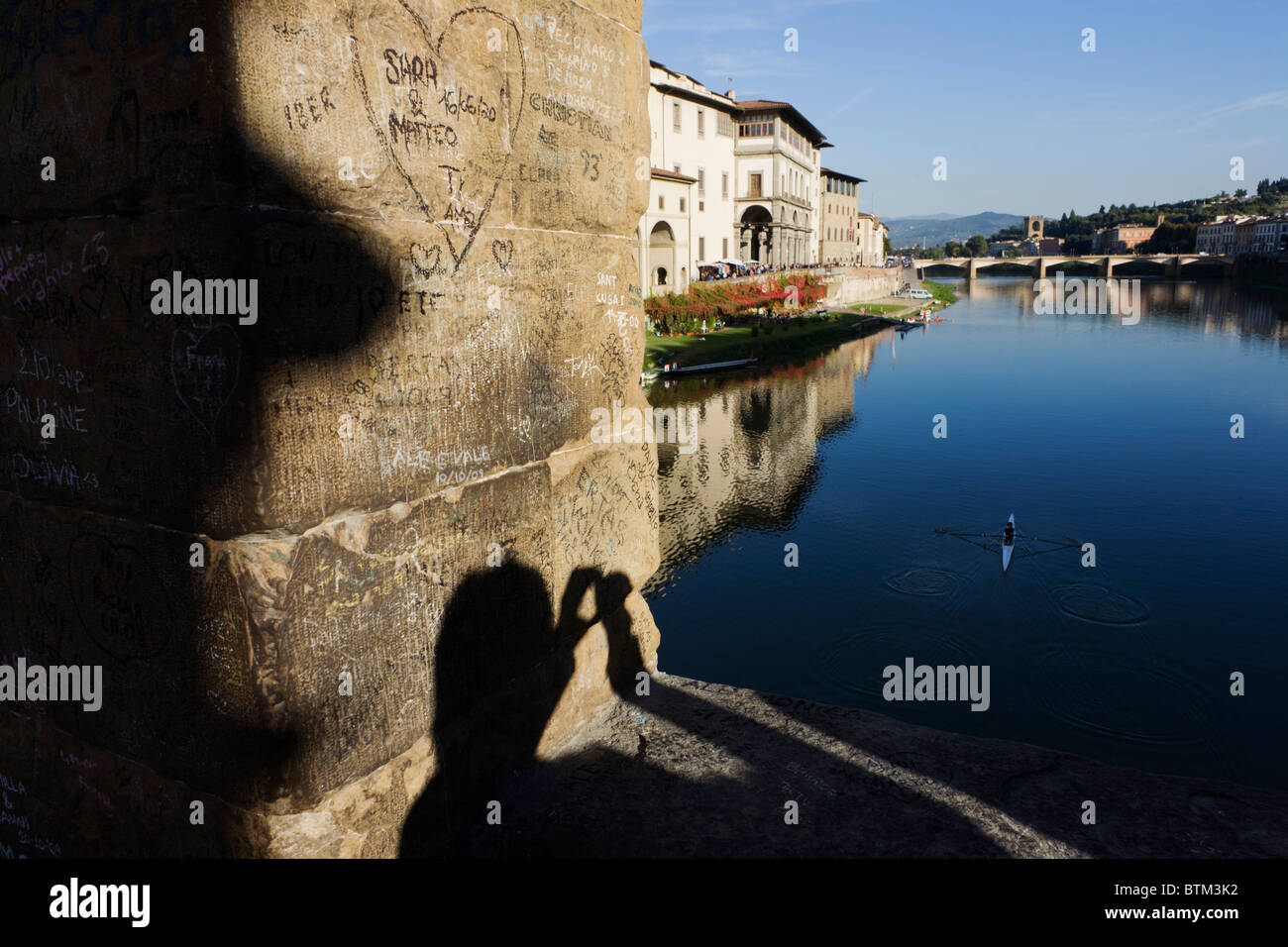 Schatten des touristischen und Säule Graffiti auf Ponte Vecchio, der Fluss Arno überquert. Stockfoto