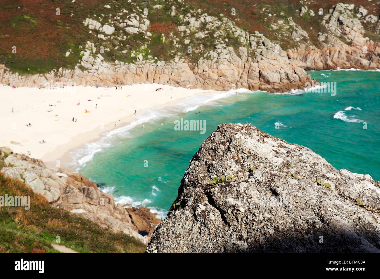 Ein Fels bietet Vordergrund Interesse im Blick von Prachtnelke über Porthcurno Strand, Cornwall Stockfoto