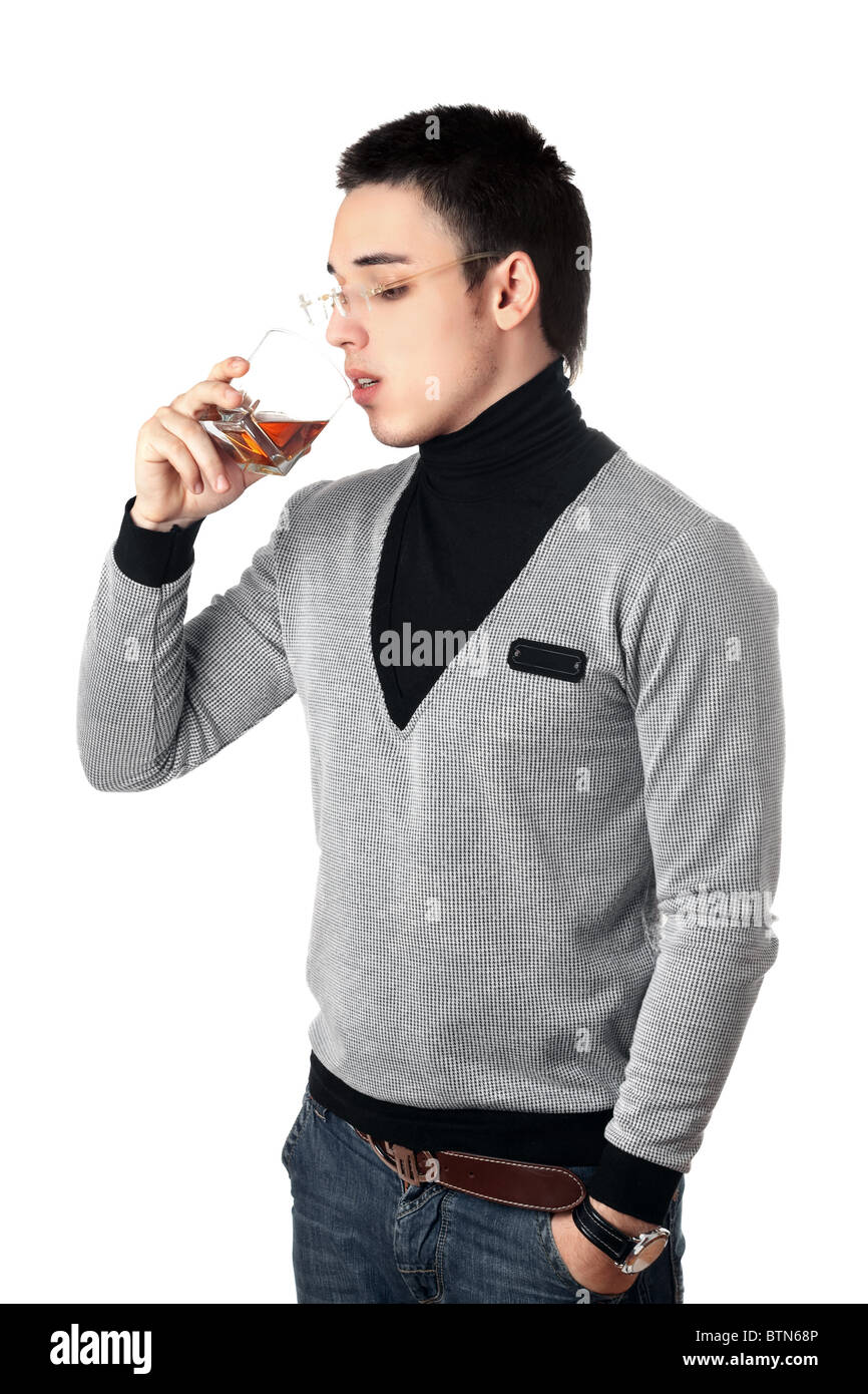 Junger Mann trinken Whisky aus einem Glas Stockfoto