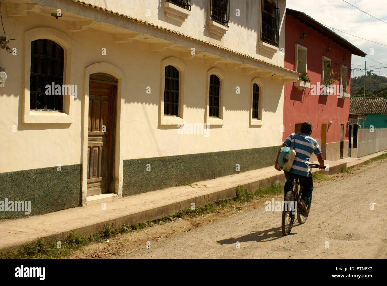 Junge mit dem Fahrrad vorbei an restaurierten Häuser in der spanischen Kolonialstadt, Gracias Lempira, Honduras Stockfoto