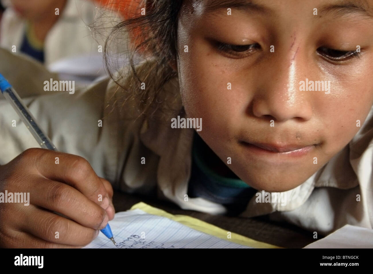 Ban Buamlao Primary School, Ban Buamlao, der Provinz Luang Prabang, Laos ein 10 Jahre altes Mädchen in einer Arbeitsmappe auf der Ban-Bu schreibe Stockfoto