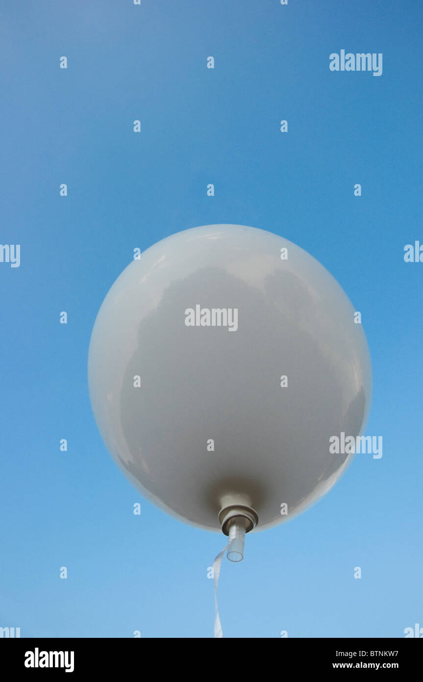Blickte zu Helium gefüllten weißen Ballon gegen blauen Himmel Stockfoto