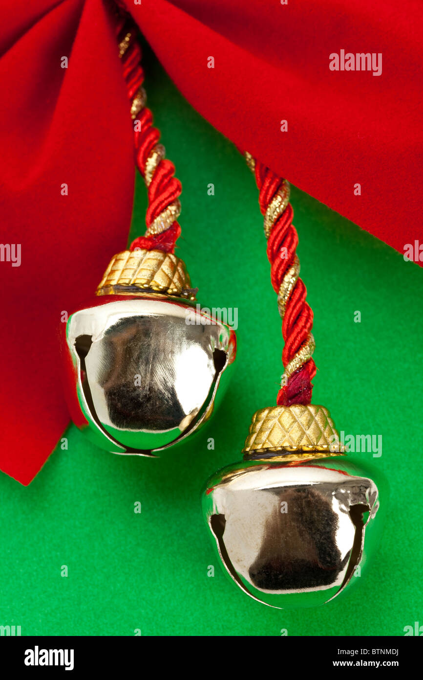 Weihnachtsglocken und Band mit grünem Hintergrund Stockfoto