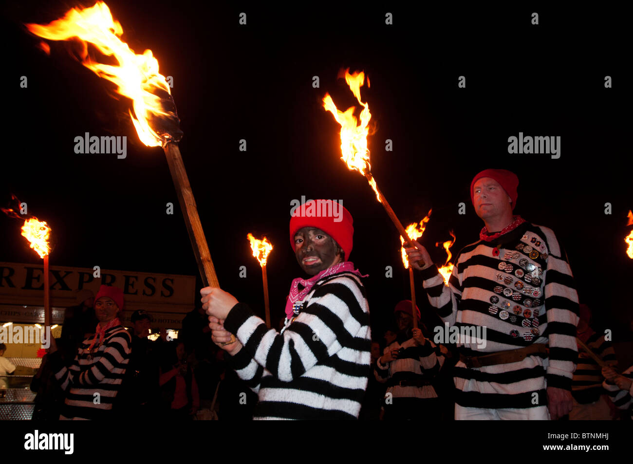 5. November 2010. Feuerwerk und Lagerfeuer Nacht, Lewes, Sussex. Cliffe Lagerfeuer Vereinsmitglieder mit brennenden Flugfeuer Stockfoto