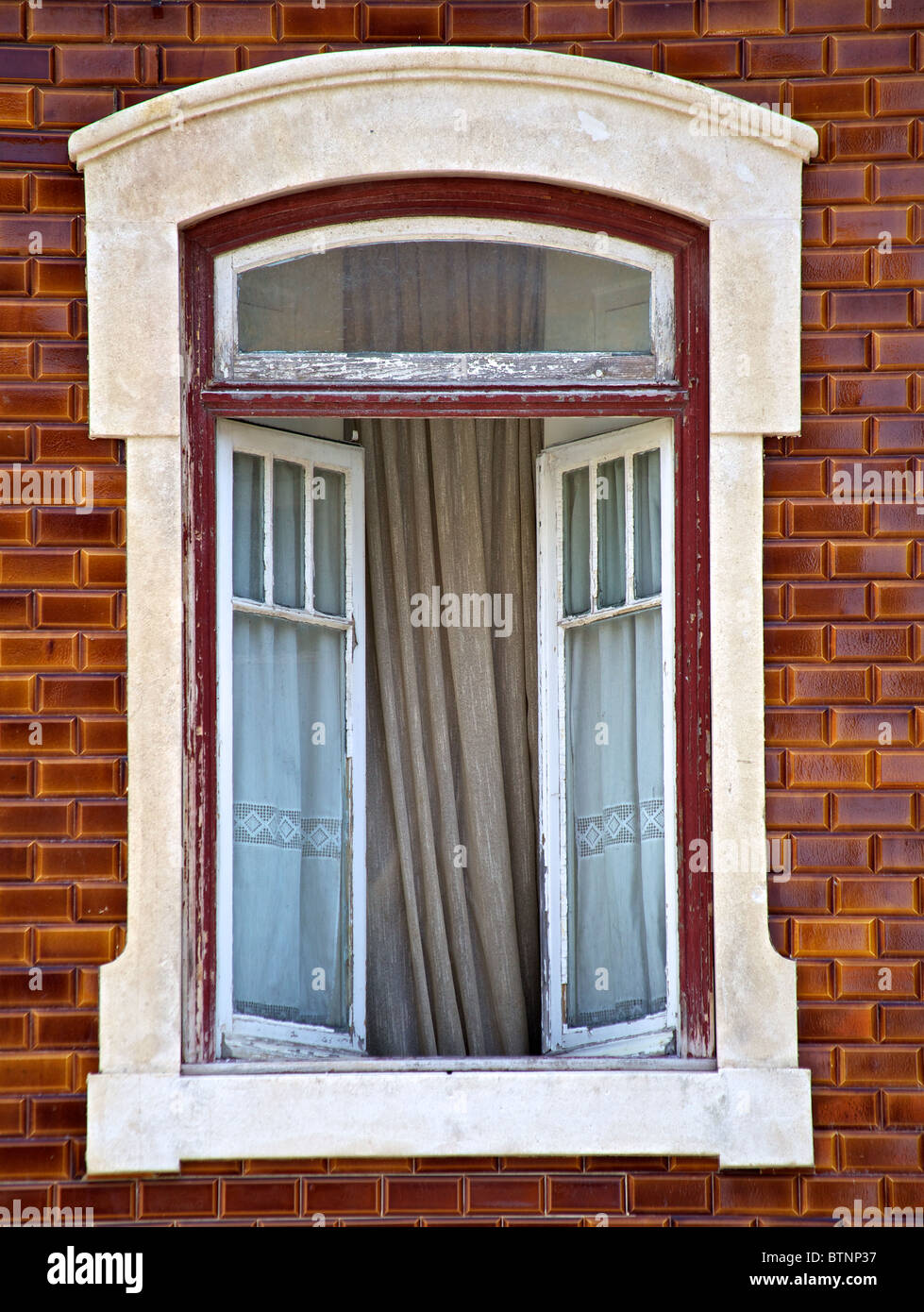 Stein gehauen Fenster gegen bräunlich Wandfliese Stockfoto