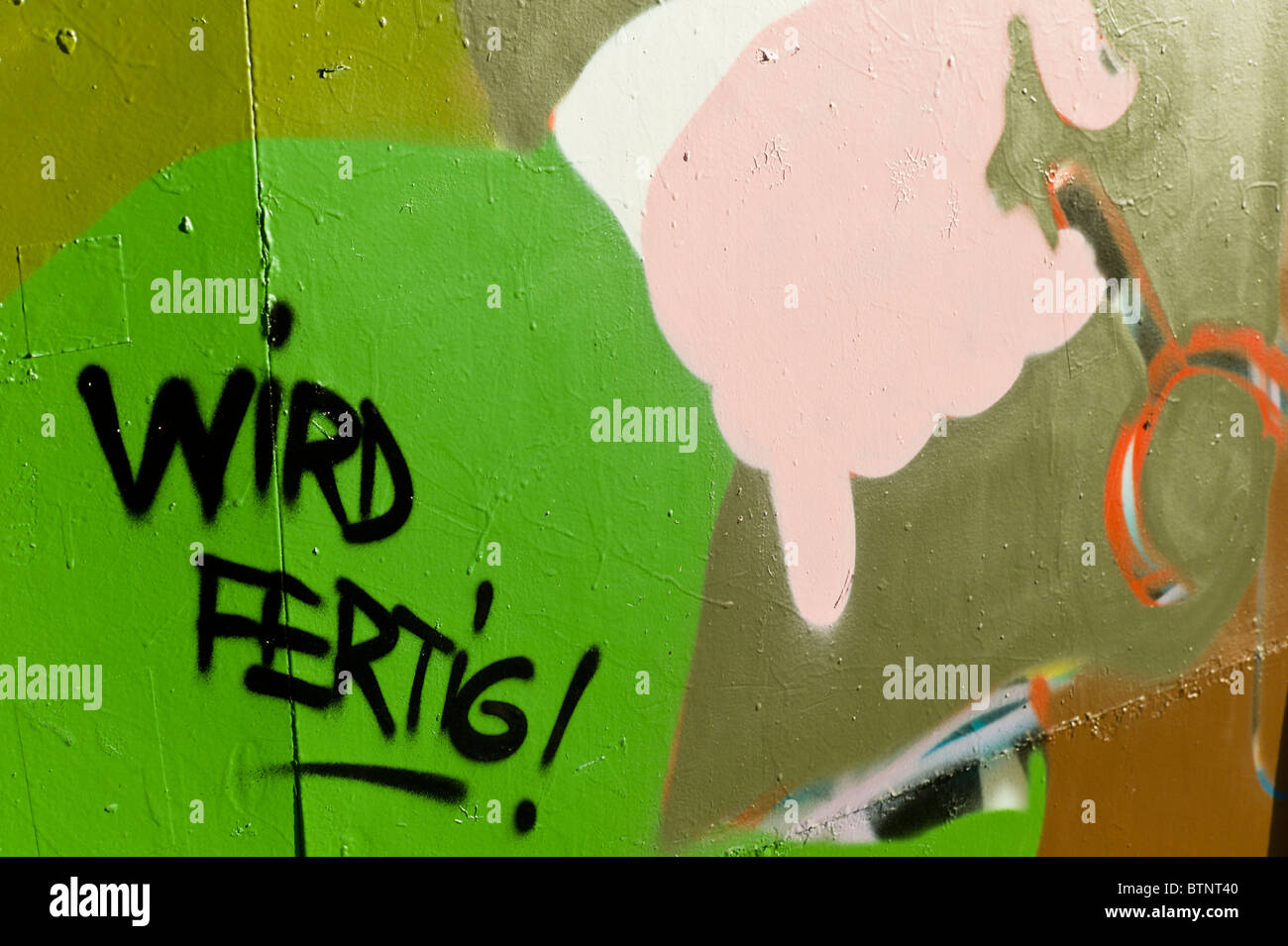 Graffiti mit einem hellgrünen Hintergrund und dem deutschen Worte "Wird Fertig!" / "fertig!". München, Deutschland Stockfoto