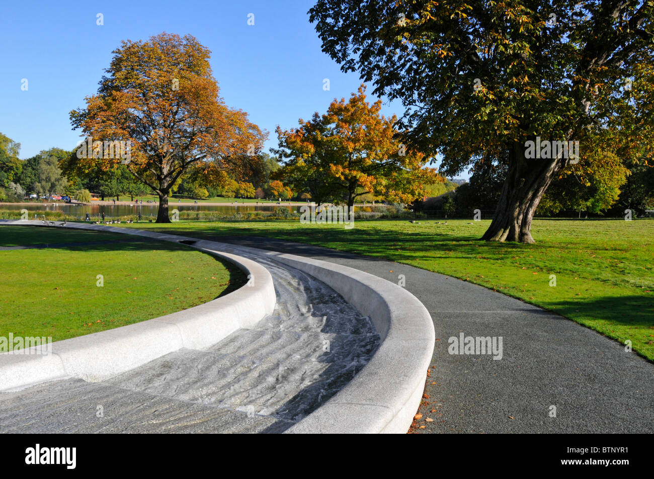 Prinzessin Diana Gedenkbrunnen im Hyde Park London England UK bilden eine kreisförmige Künstliche rill Wasserspiel mit Herbstfarben auf Bäumen Stockfoto