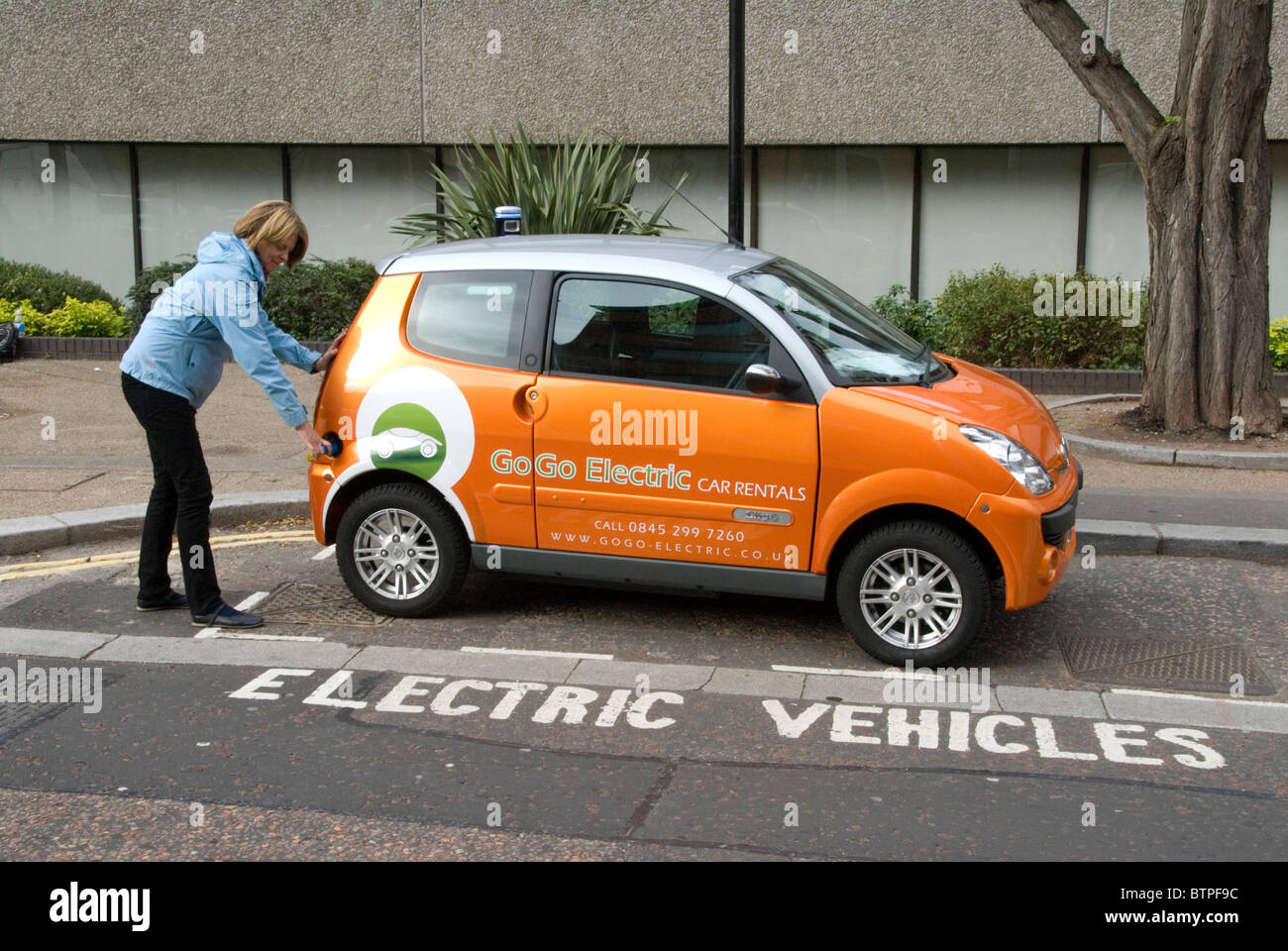 Frau einstecken Elektrofahrzeug an kostenlosen EV kostenlos Point South Bank London UK GoGo Elektrofahrzeuge Verleih Stockfoto