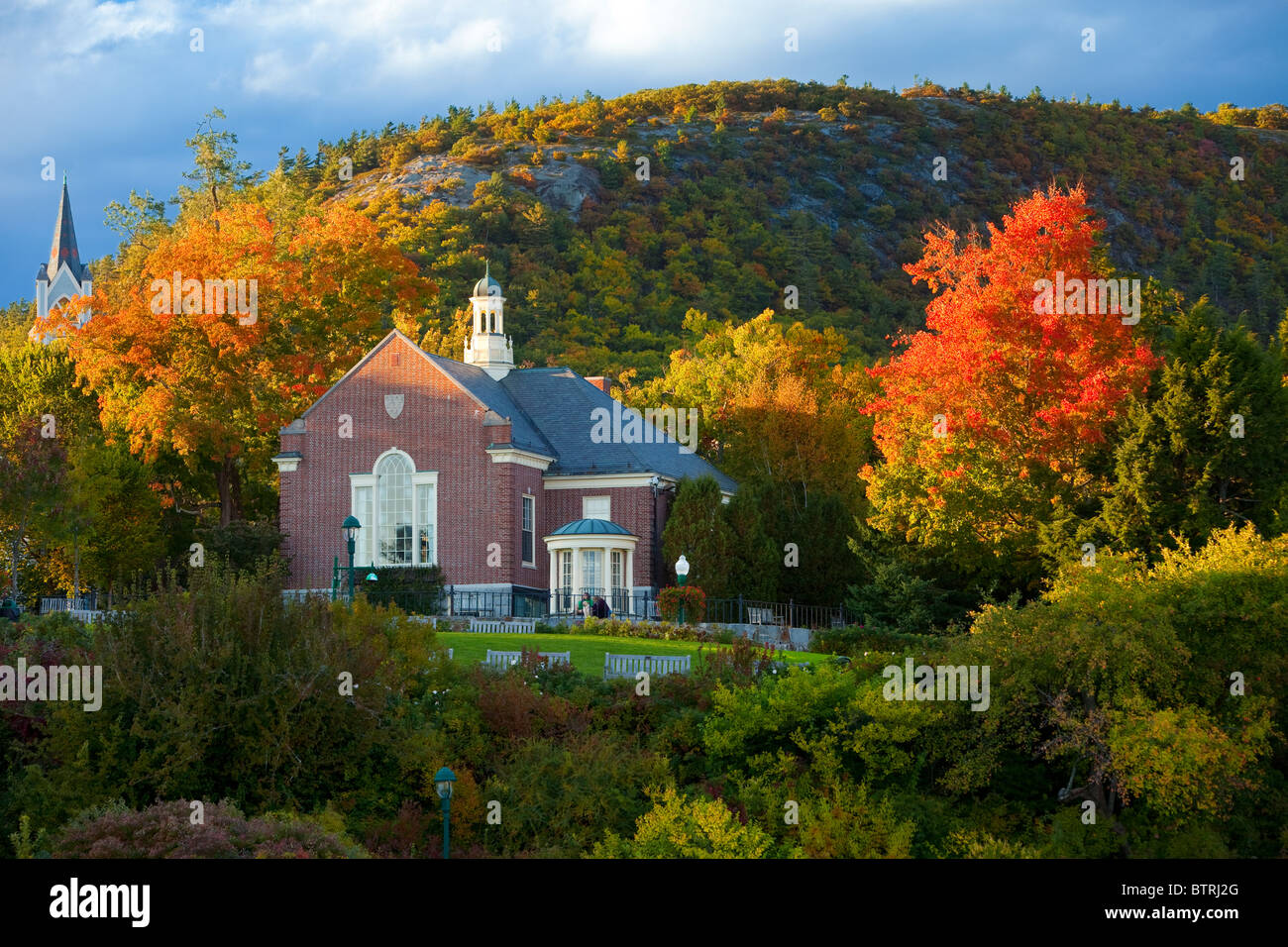 Herbstlaub umgibt die Camden Bibliothek oberhalb des kleinen Hafens in Camden Maine USA Stockfoto