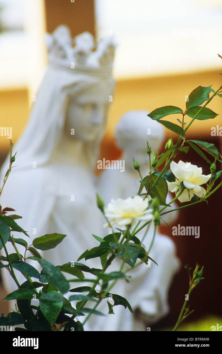 Statue Jungfrau Maria Mutter Gottes halten Baby Jesus Krone weißen Garten Frieden Liebe selbstlose Pflege fürsorgliche Liebe beten Stockfoto