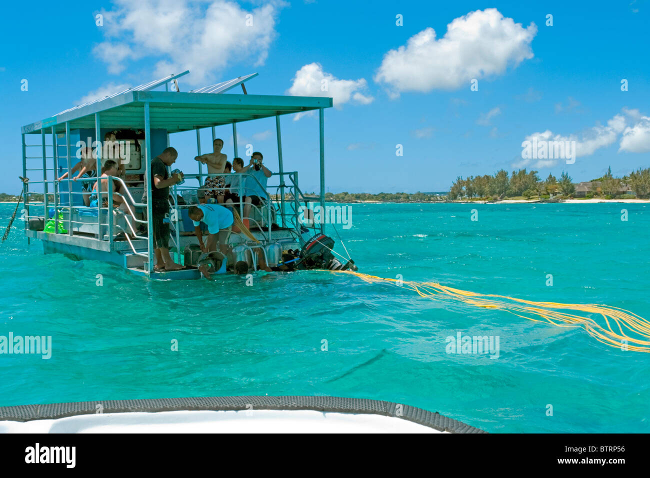 Touristen in Mauritius absteigend von der Plattform für den berühmten Unterwasser-Spaziergang über das Riff in der Nähe von Grande Baie verankert Stockfoto