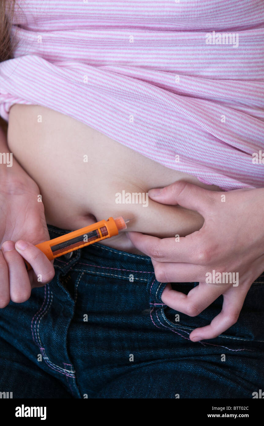 Junges Mädchen geben sich selbst eine Insulininjektion in den Bauch zur Behandlung von Typ 1 diabetes Stockfoto