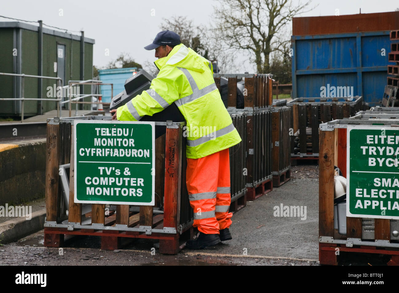 Workman Entsorgung eines alten TV in Container im Rat ablehnen site für Hausmüll. Großbritannien Großbritannien Stockfoto