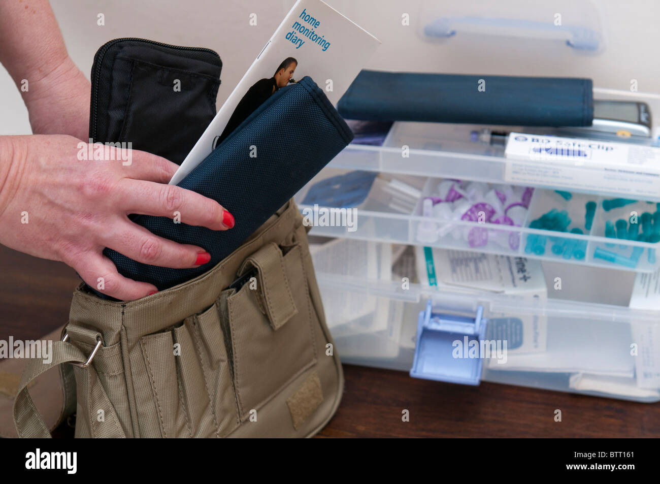 Nahaufnahme von Händen setzen Diabetes Überwachung Ausrüstung und Datensätze in einer Tasche mit Diabetes-Ausrüstung-Box im Hintergrund Stockfoto