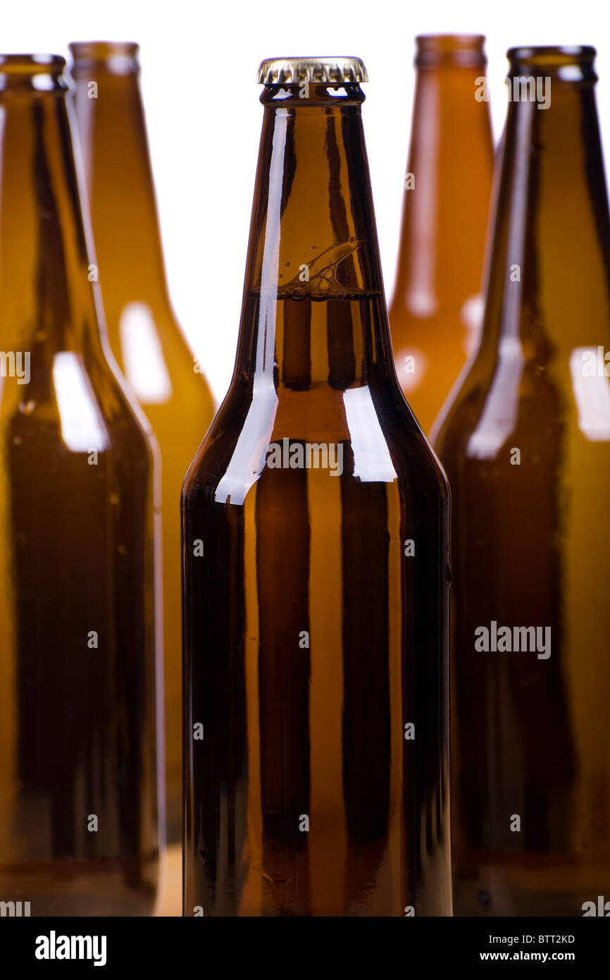 dunkle braune Glasflaschen voller Bier auf weiß Stockfoto