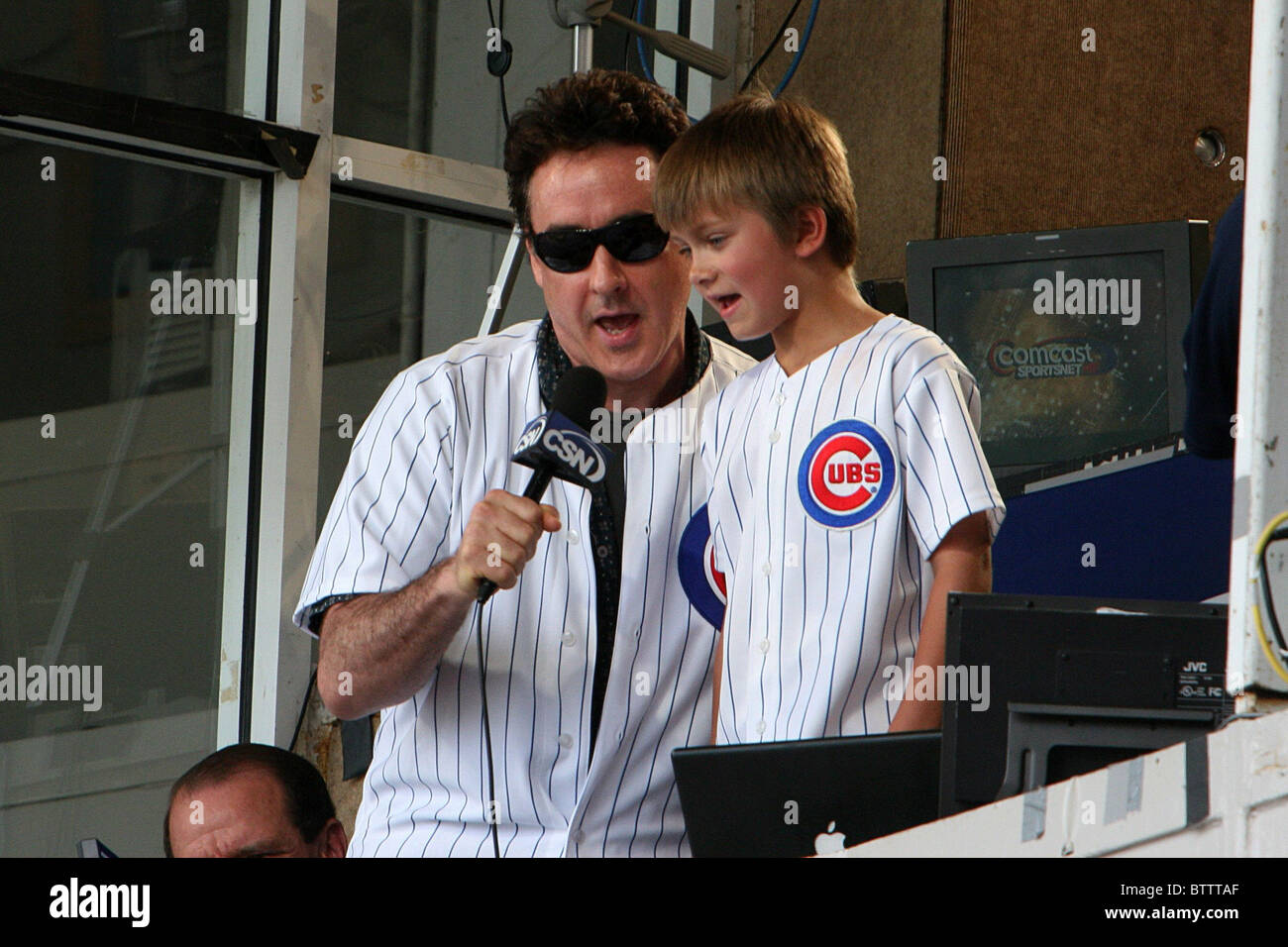 John Cusack singt im 7. Inning Stretch in Chicago Cubs Baseball Spiel vs. Pittsburgh Piraten Stockfoto