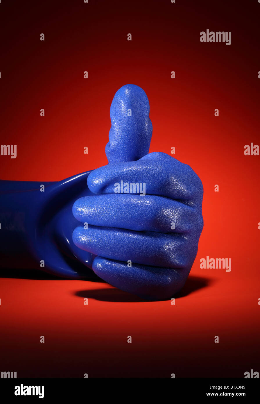 Eine große blaue Industriearbeit Handschuh. Hand in der Position ein Daumen auftauchen. Stockfoto