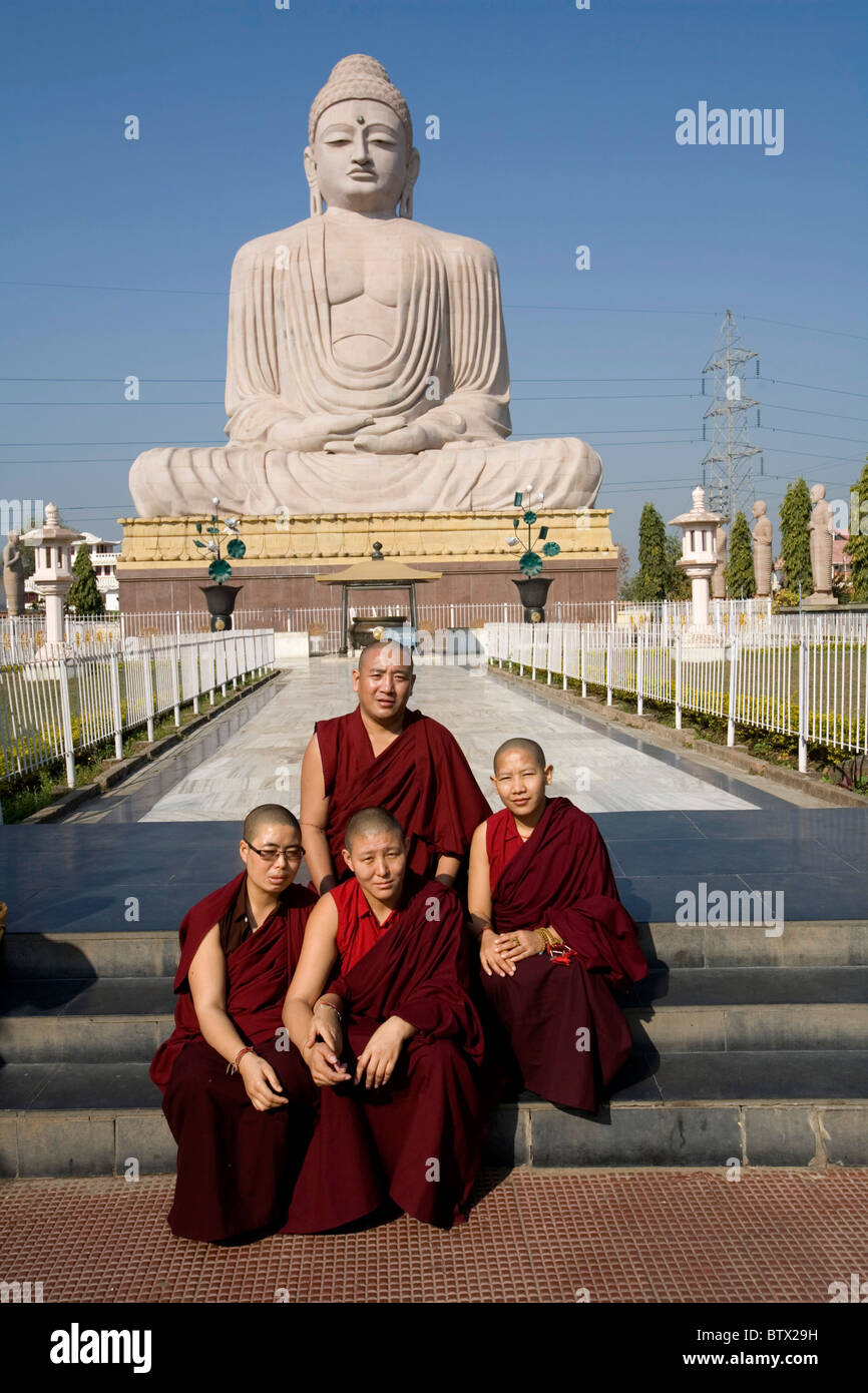 Tibetisch-buddhistische Mönche und Nonnen posieren für ein Foto vor der großen Buddha-Statue, Bodhgaya, Bihar, Indien. Stockfoto