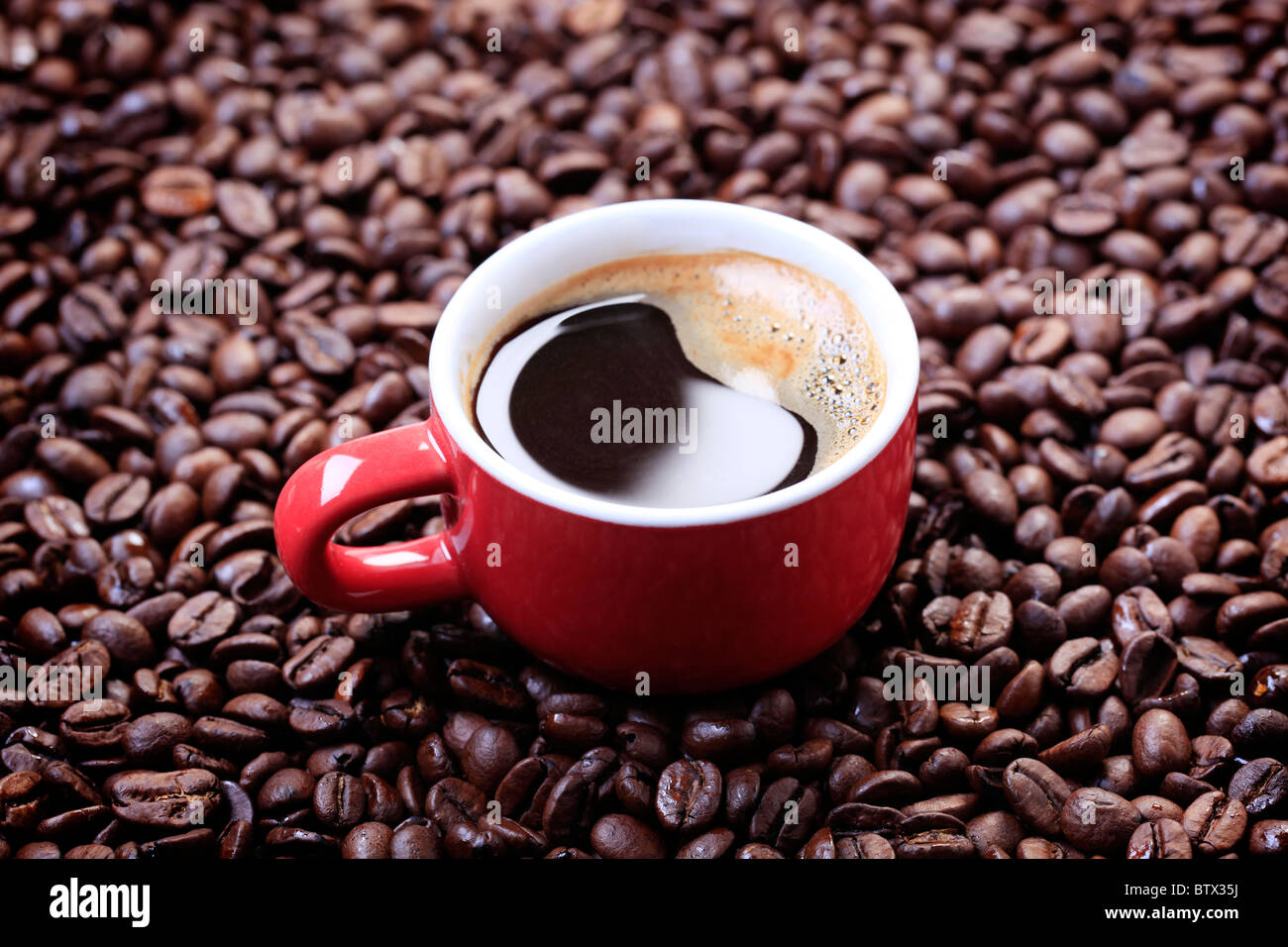 Schwarzen Kaffee auf einem Bett aus Kaffeebohnen Stockfoto