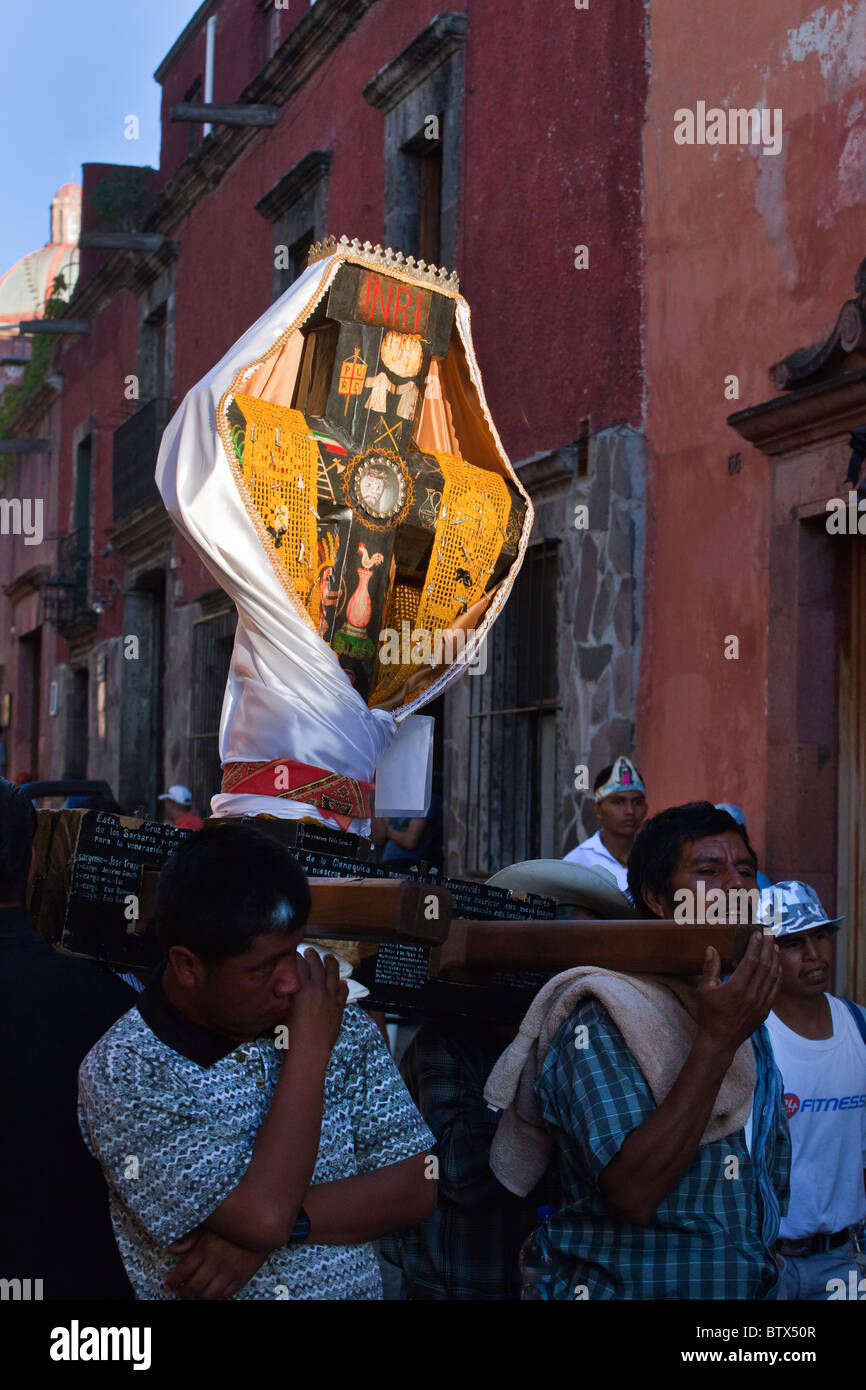Ein Kreuz zu tragen, in einer Parade durch die Straßen zur Feier des San Miguel Arcangel, in San Miguel de Allende, Mexiko Stockfoto