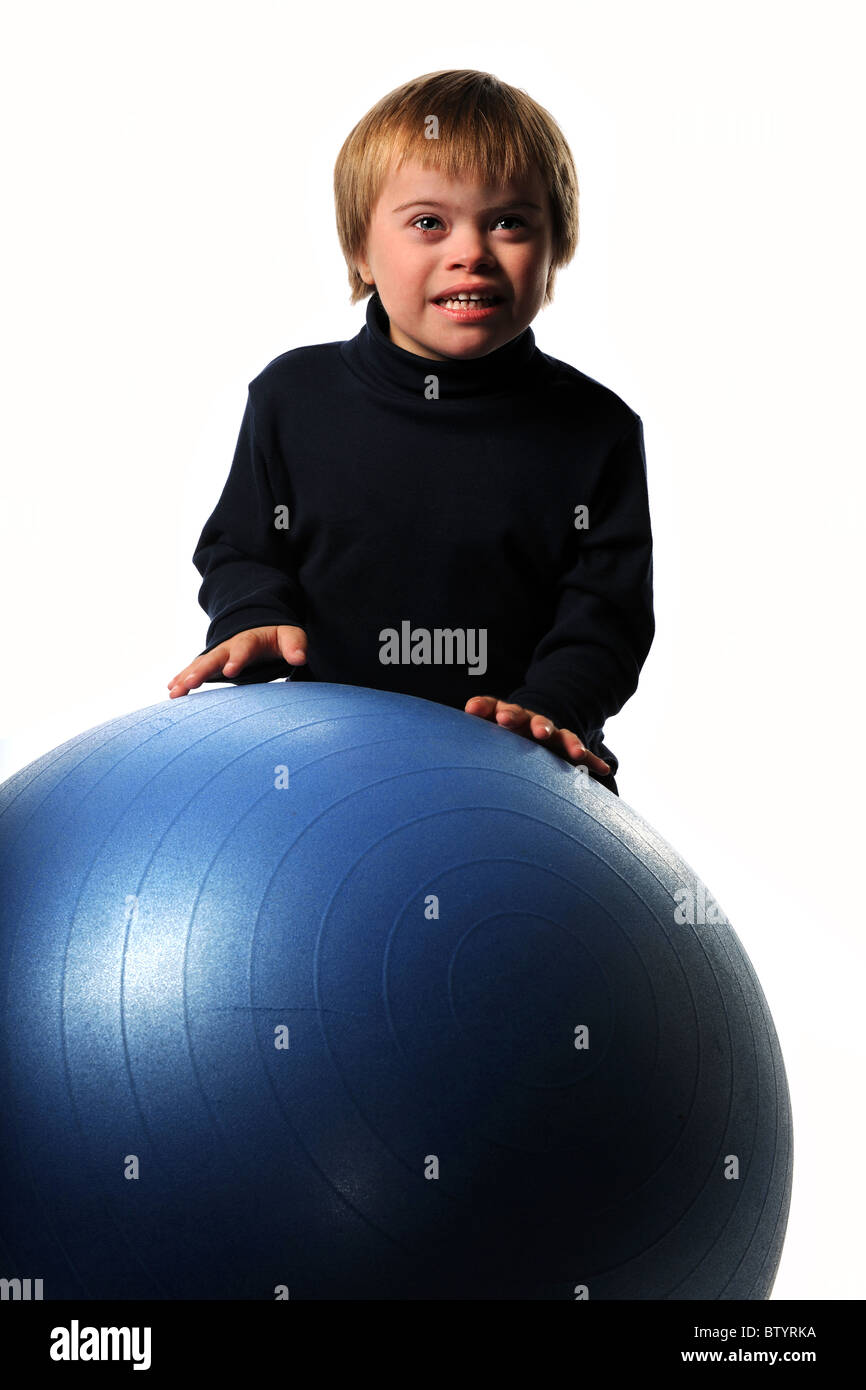 Junge mit Down-Syndrom spielt mit Ball isoliert auf weißem Hintergrund Stockfoto