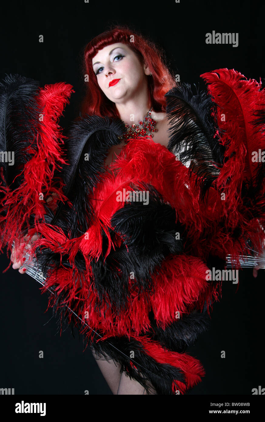 Burlesque Darsteller mit roten und schwarzen Fans tanzen Stockfoto