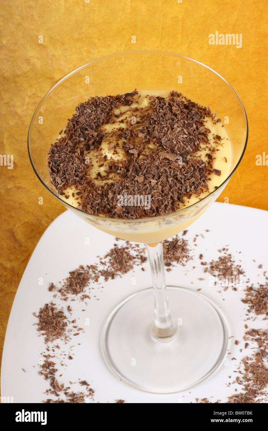 Vanille Pudding Creme mit Schokolade Dessert serviert in einem Glas auf einem weißen Teller. Stockfoto