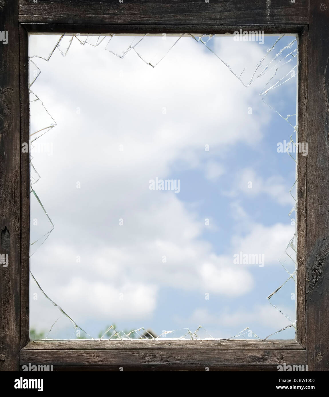 Zerbrochenes Fenster mit alten Holzrahmen, Himmelshintergrund Stockfoto