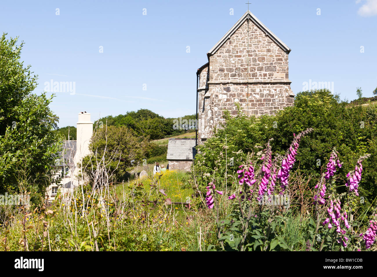 Eine Priesterin Gruß Gottesdienstbesucher in den monatlichen Nachmittag Dienst an der kleinen, abgelegenen Kirche Stoke Pero, Exmoor, Somerset Stockfoto