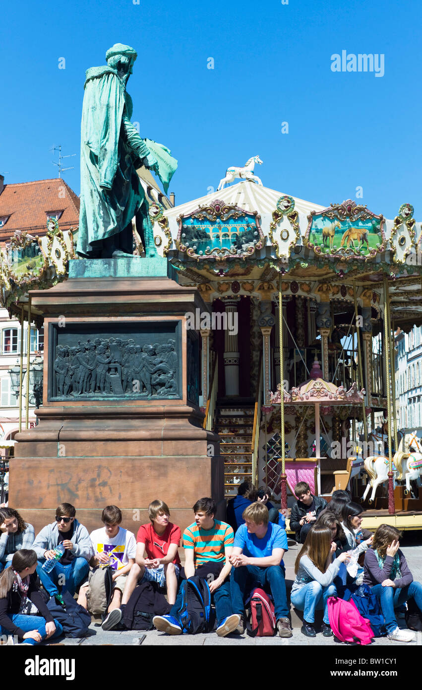 Junge Leute sitzen durch Gutenberg Monument, Straßburg, Karussell, Place Gutenberg Platz, Straßburg, Elsass, Frankreich, Europa Stockfoto