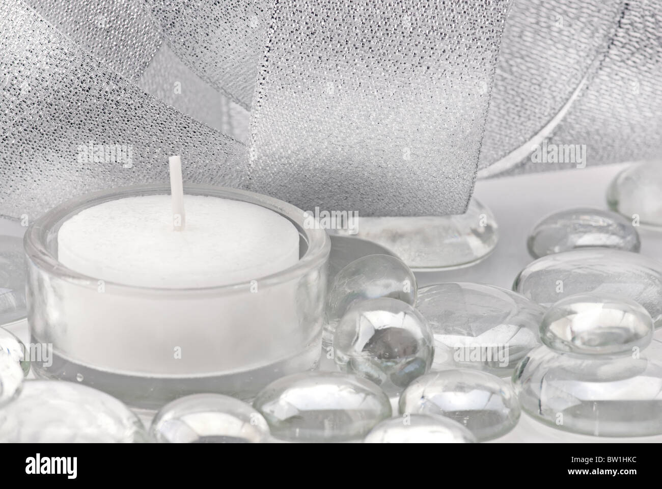 Silber farbige Dekoration mit Kerzen, Glastropfen und leuchtendes Band Stockfoto