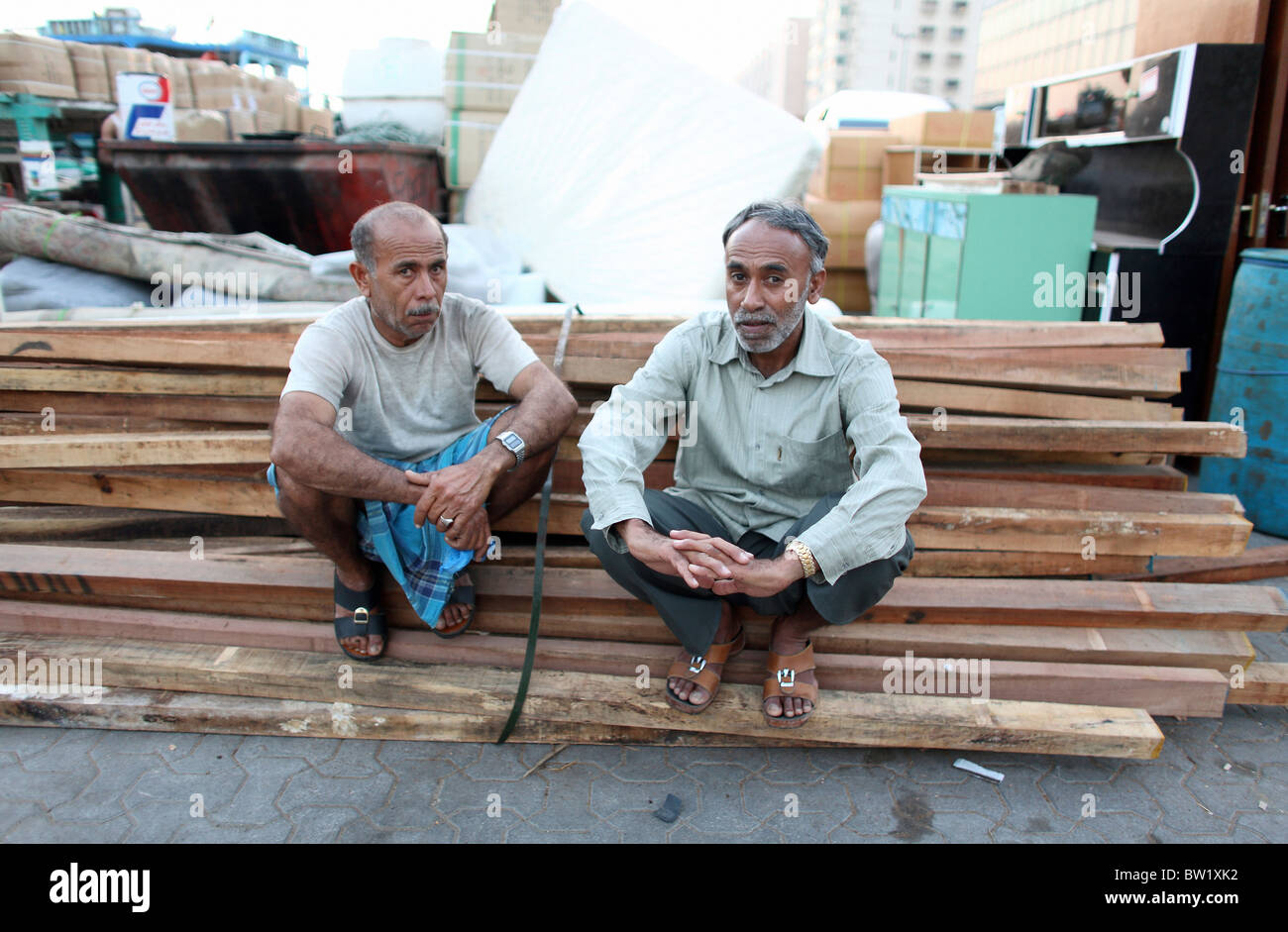 Männer sitzen auf einem Haufen Holz, Dubai, Vereinigte Arabische Emirate Stockfoto