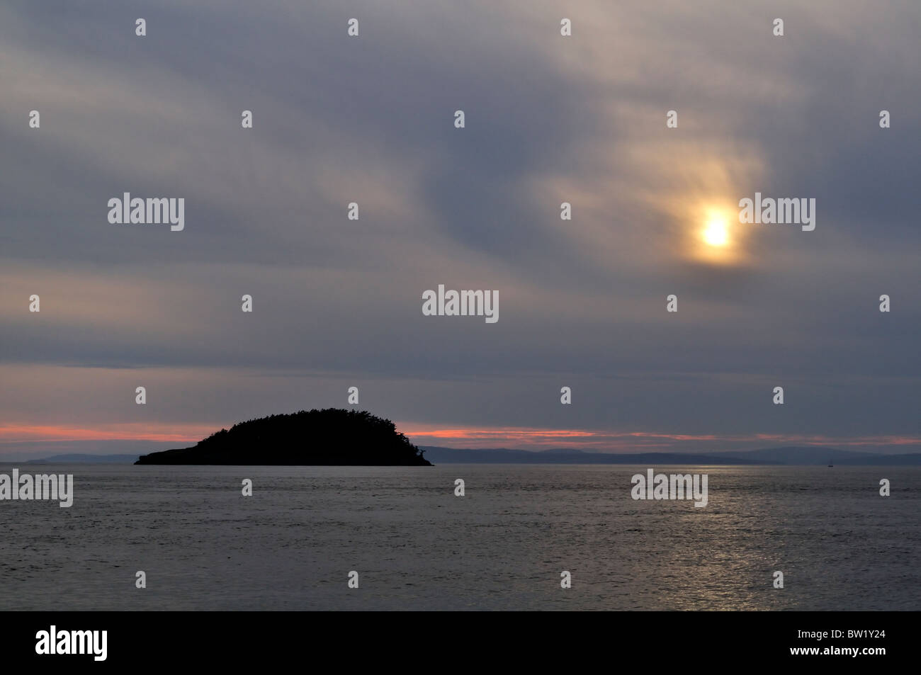 Sonne, spähen durch grauen Himmel auf Deception Pass, Puget Sound, Washington. Stockfoto