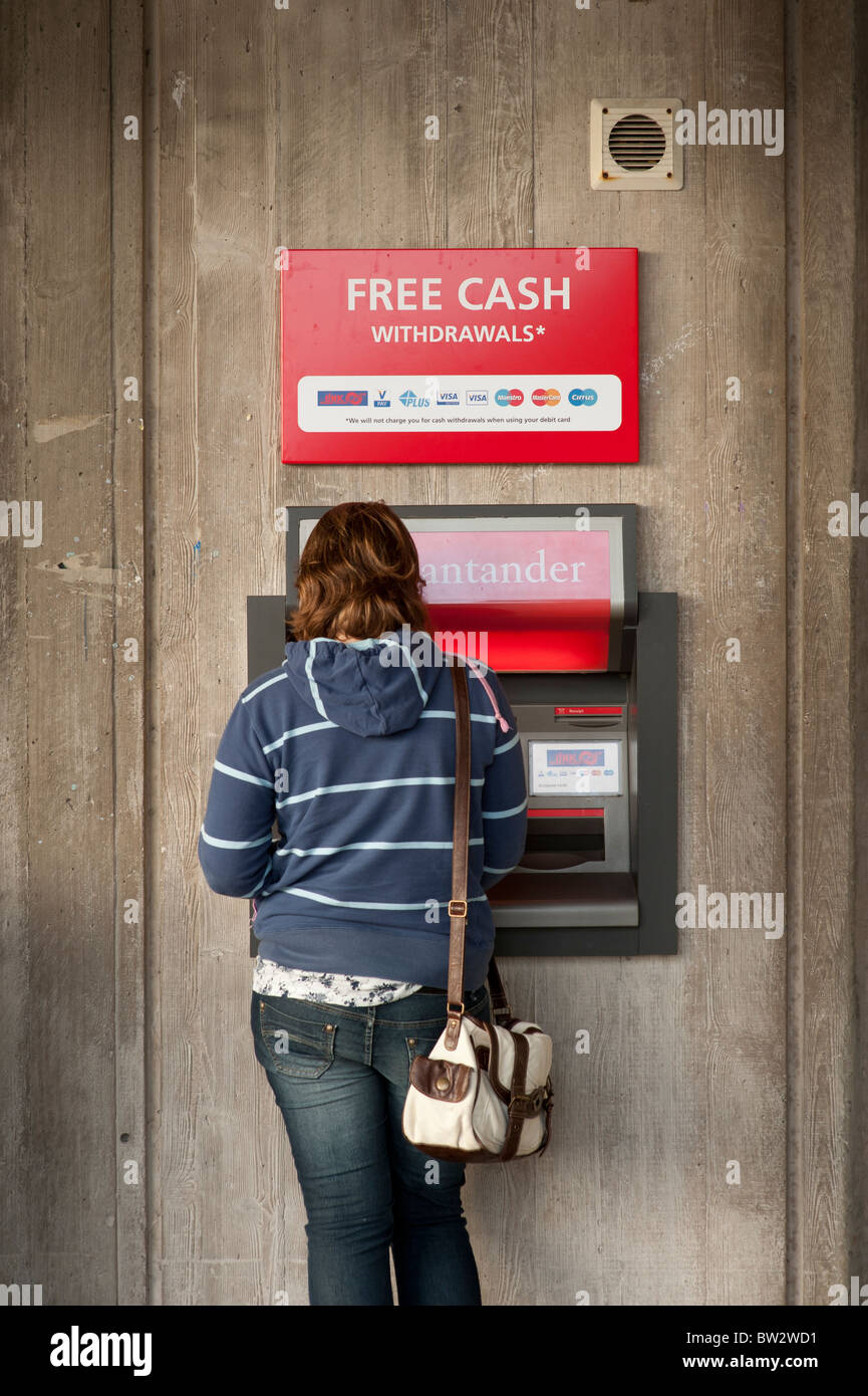 Student mit einer Santander ATM Bargeld darauf Maschine auf dem Campus der Aberystwyth University Wales UK Stockfoto