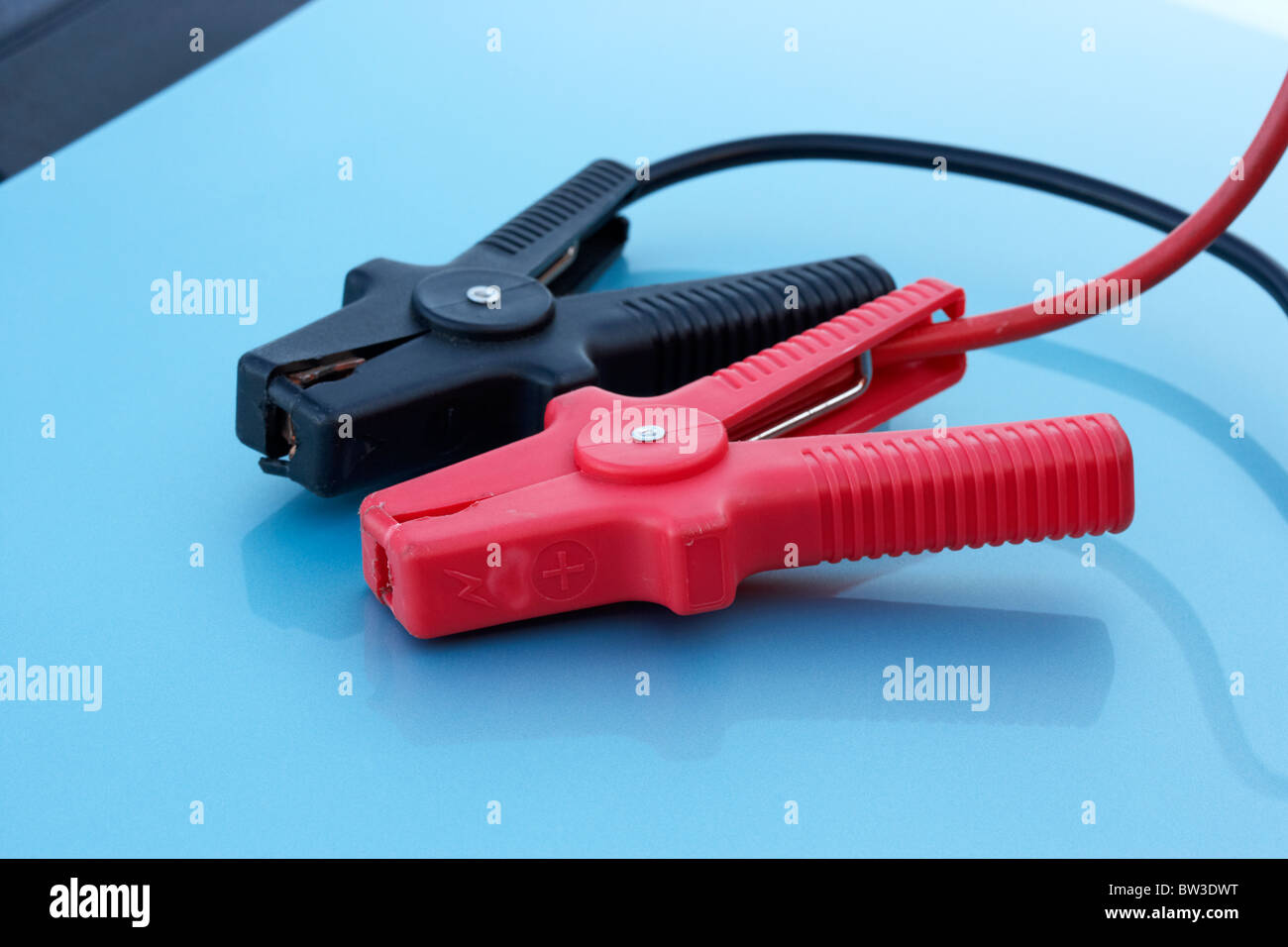 rote und schwarze Sprung führt Steckverbinder auf eine Motorhaube Stockfoto