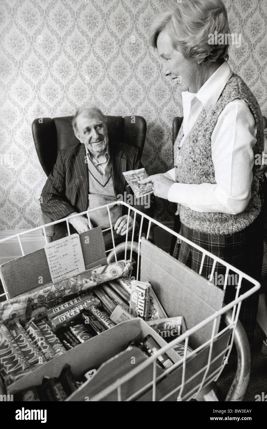 Dame aus WRVS Verkauf älterer Mann von Süßigkeiten aus Trolley eine vollstationäre Pflege zuhause Stockfoto