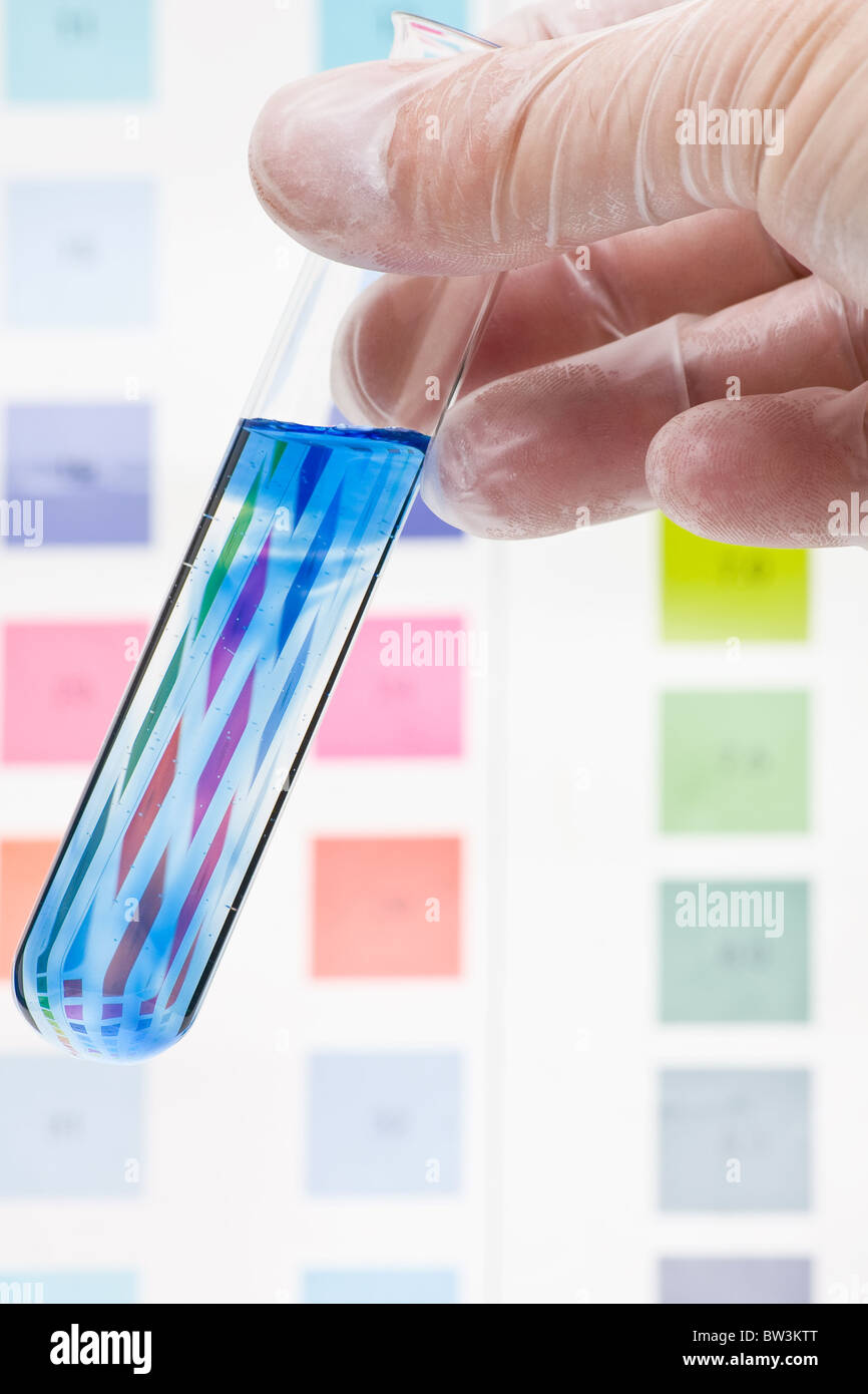Hand hält Reagenzglas mit pH-Indikator, Farbe, skalieren zu vergleichen Stockfoto