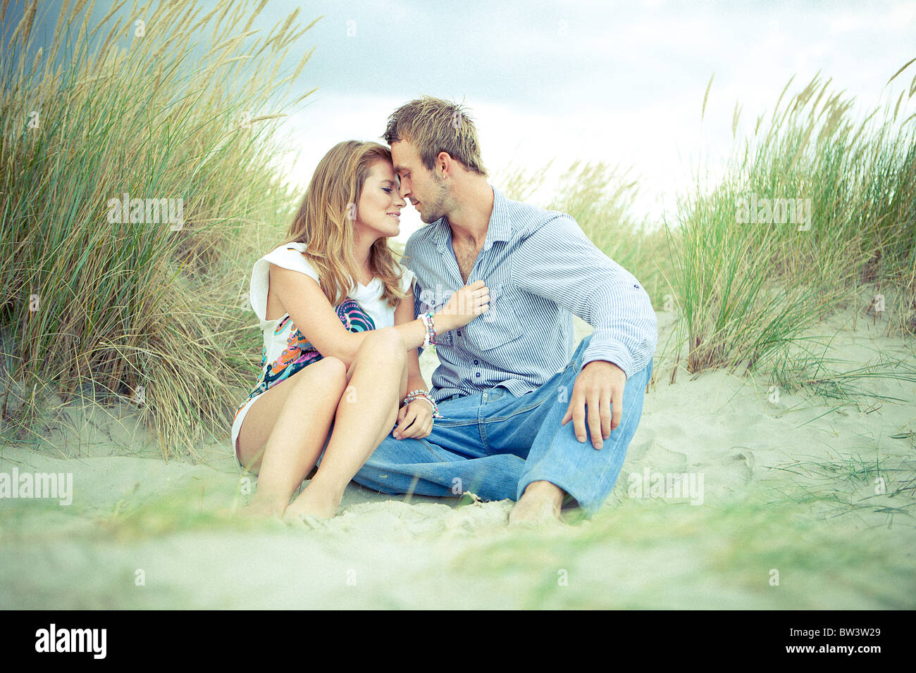 Junges Paar küssen auf Sanddünen Stockfoto