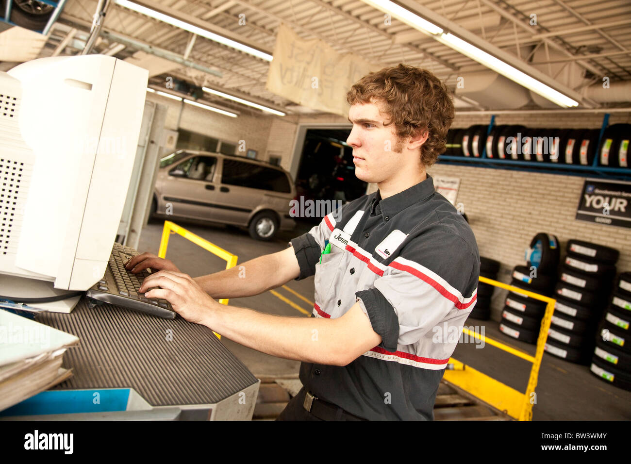 Junge Mechaniker an einem Computer arbeiten Stockfoto