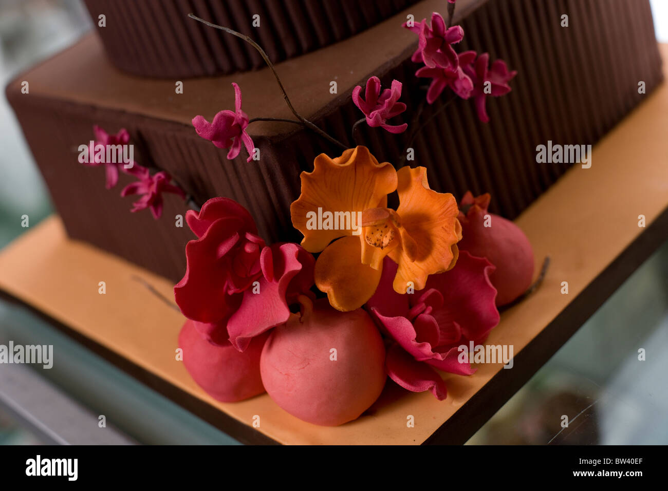 Nahaufnahme von Braun abgestufte Kuchen, Pink und Orange Blumen Dekorationen Stockfoto