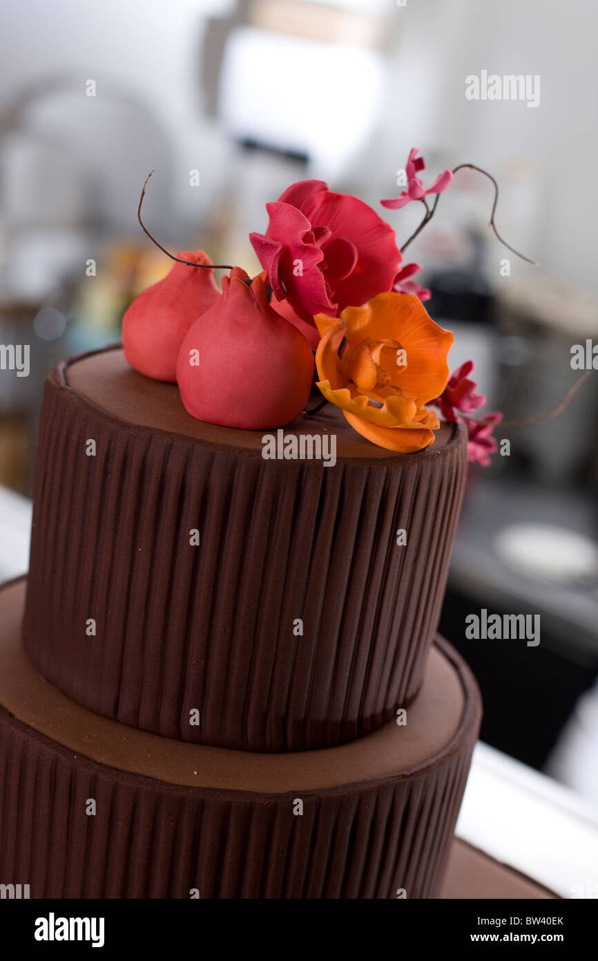 Spitze der abgestuften Kuchen, braun mit rosa und orange Blumenschmuck Stockfoto